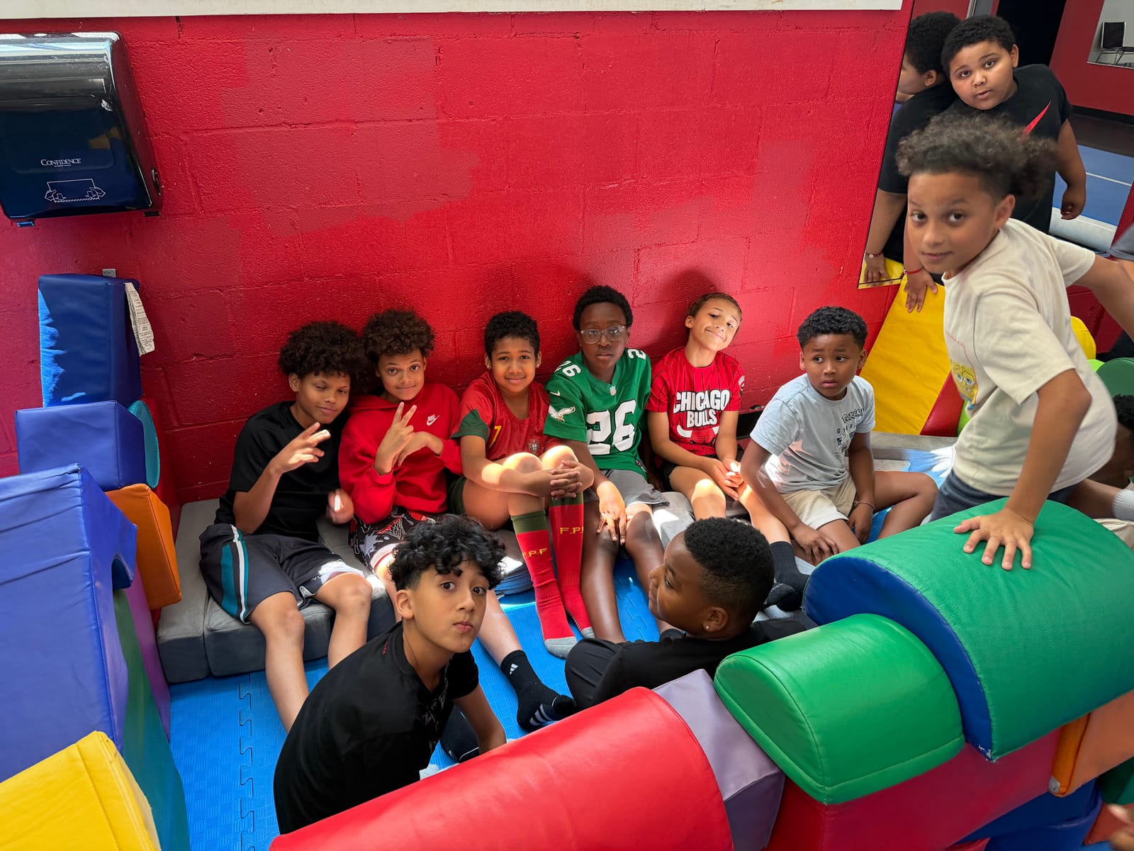 Group of students posing on colorful soft-play equipment